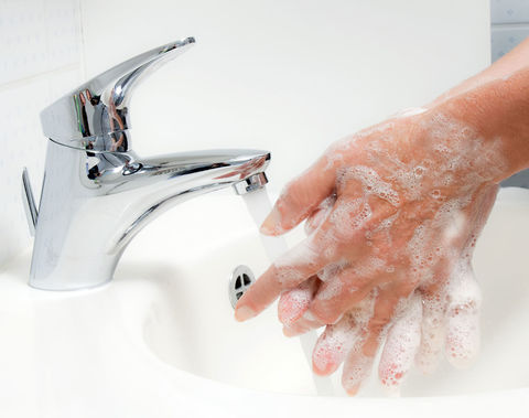 Eingeseifte Haende werden unter dem laufenden Wasserhahn gewaschen Eingeseifte Haende unter laufendem Wasser waschen