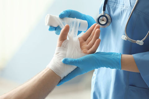 Mediziner wickelt Verband um Handgelenk